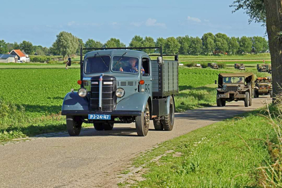Oude voertuigen rijden op een landweggetje