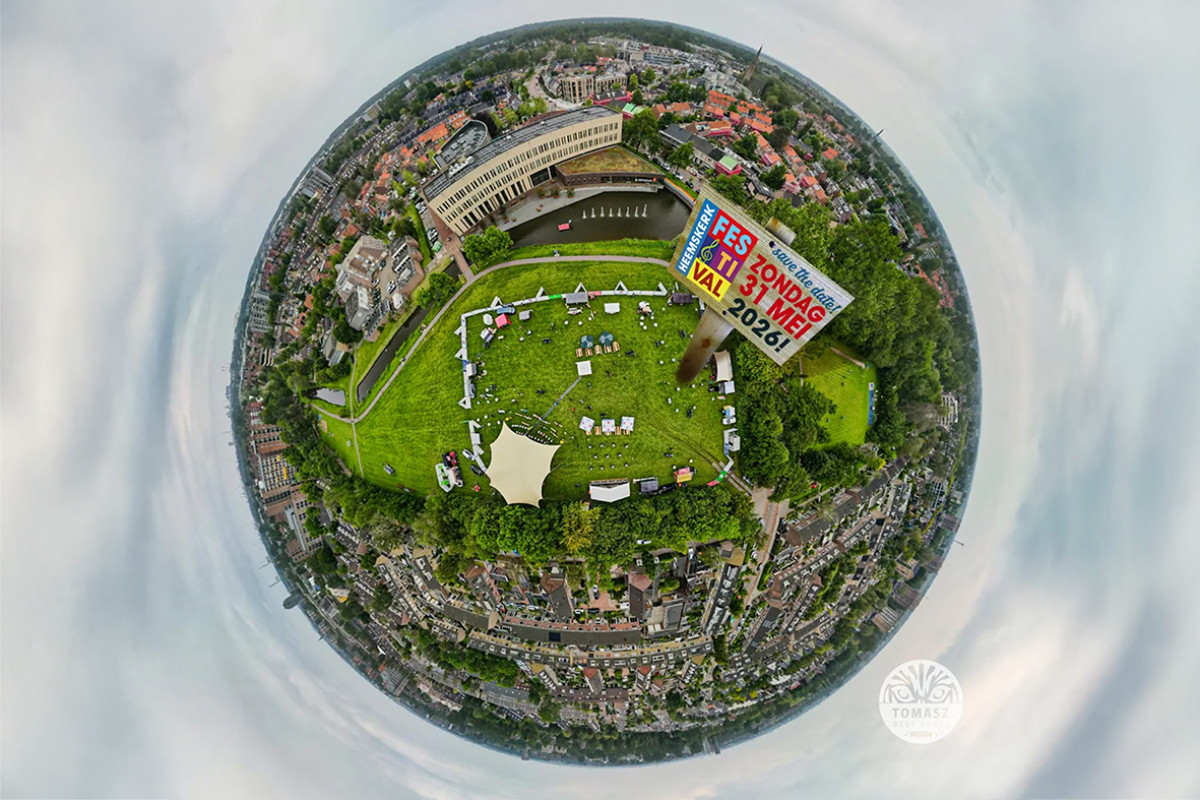 Luchtfoto met grasveld en tenten en een bord met logo heemskerk festival