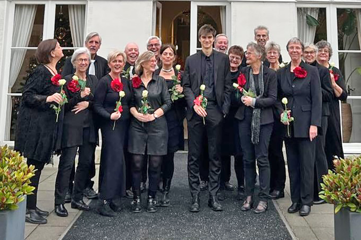 Groep mensen in het zwart houden een rode roos vast