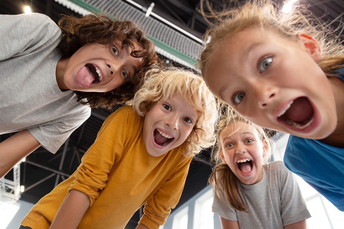 vier kinderen kijken van bovenaf in de camera