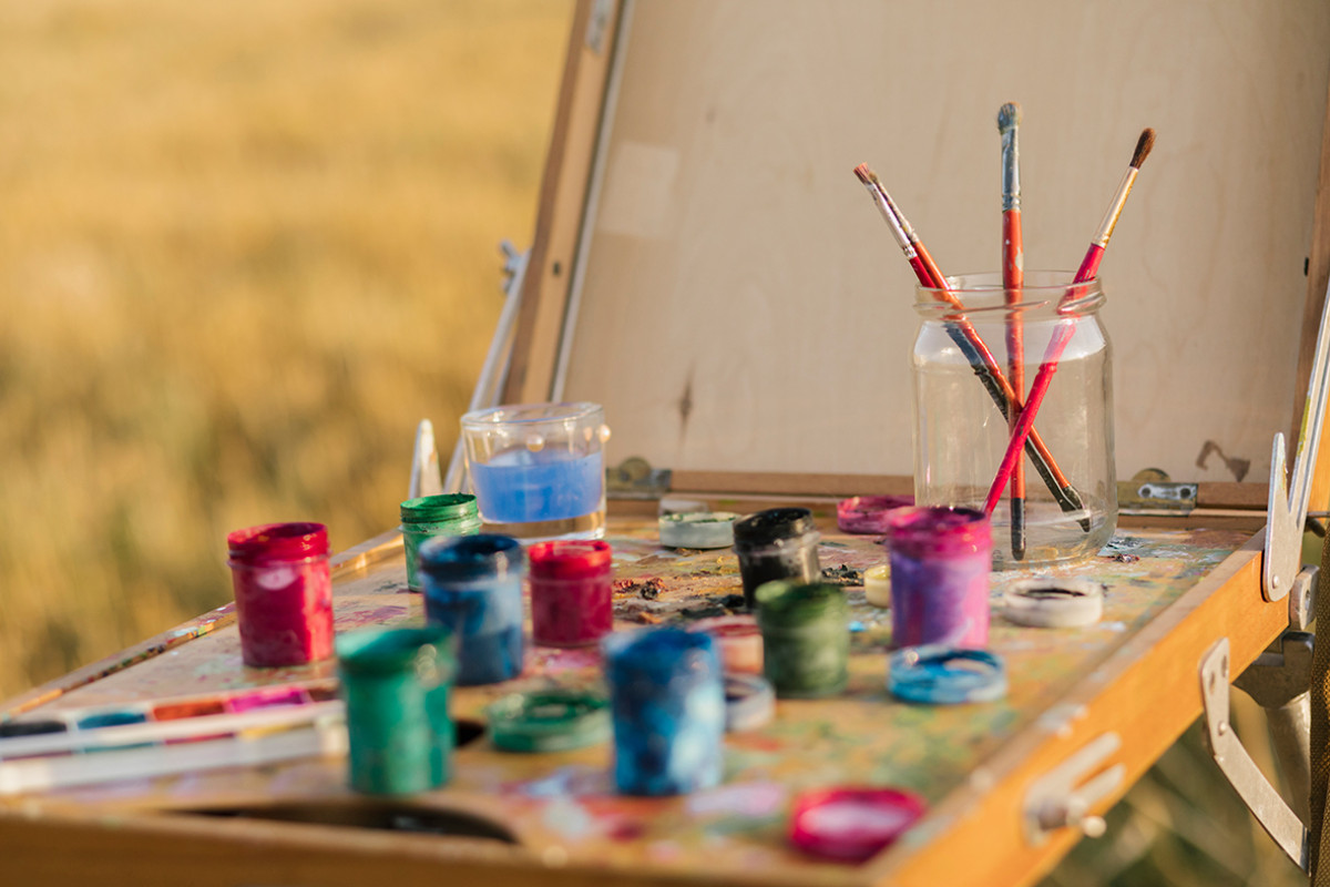 verfpotjes staan buiten bij schilderij