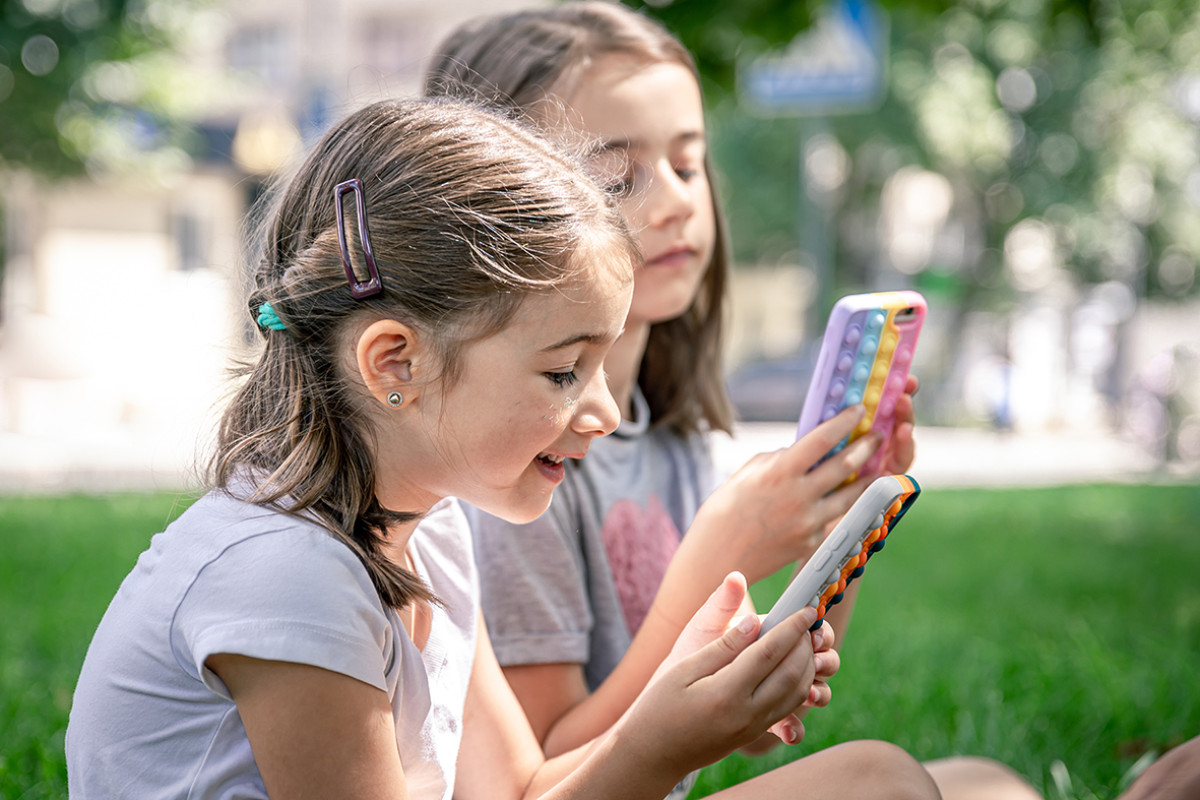 Twee meisjes kijken op hun telefoon