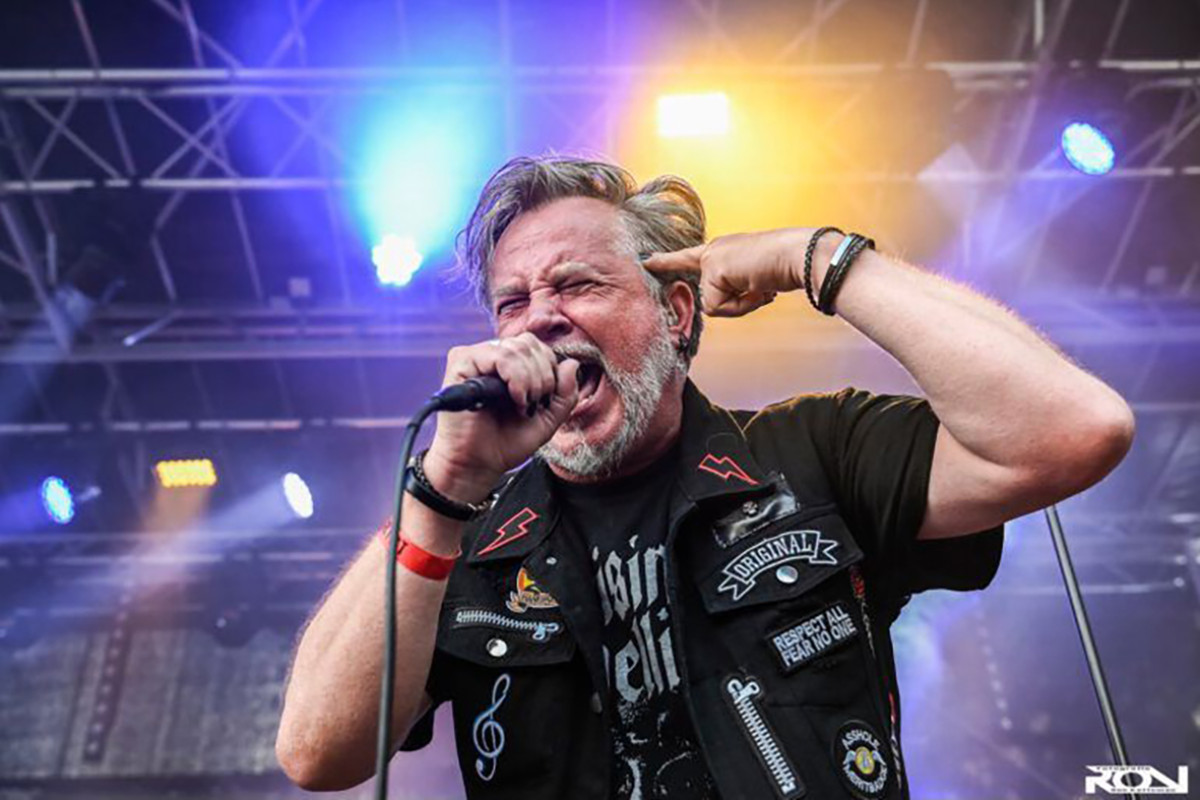 Man zingt in microfoon met ogen dicht